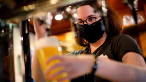 Member of bar staff wearing face covering