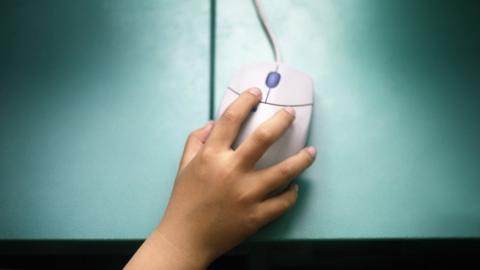 Child's hand on computer mouse