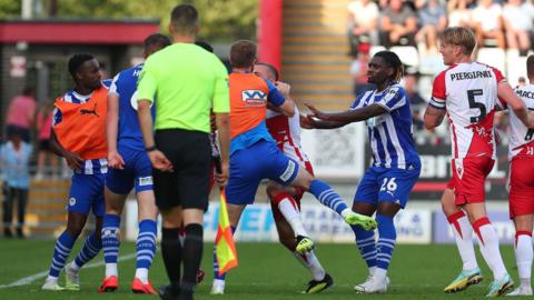 Stevenage and Wigan Athletic players confront each other during their League One fixture on 7 October