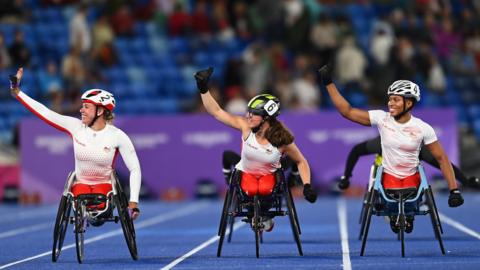 Gold medallist Hannah Cockroft, third placed Fabienne Andre and runner-up Kare Adenegan celebrate their 1-2-3 in the women's T33/34 100m at the Birmingham Commonwealth Games