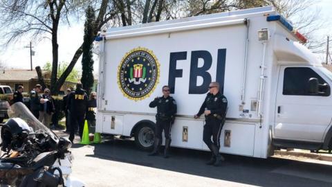 Photograph of FBI van with officials outside at crimes scene