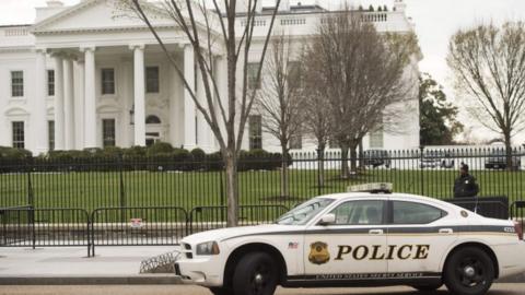 Members of the Secret Service Uniformed Division patrol alongside the security fence around the perimeter of the White House in Washington, DC, on March 18, 2017.