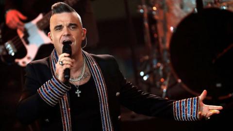 Robbie Williams singing on stage