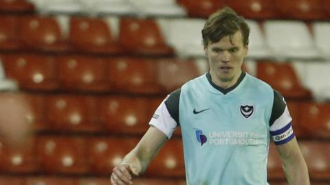 Portsmouth defender Sean Raggett says they will keep pushing for the playoffs despite Barnsley defeat.