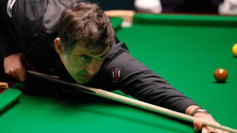 Ronnie O'Sullivan focusing as he plays a shot at the World Championship
