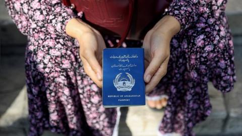 Afghan refugee holding her passport
