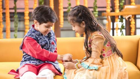 girl trying a bracelet to boy's wrist