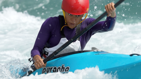 A female kayaker paddling through white water