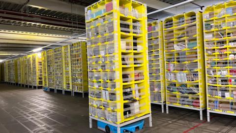 A large yellow Hercules Drive robot moving goods around Amazon's LCY3 depot in Dartford.
