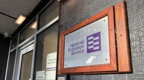The entrance to a probation service building showing a plaque on the side of a door reading 'National Probation Service'