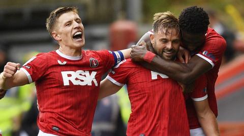 Charlton players celebrate with goalscorer Matty Godden after his late penalty equaliser against Wrexham.