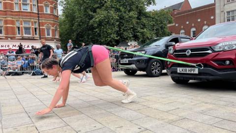 A woman pulling a car 