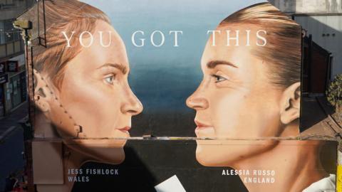 Paentiad murlun ar ochr y wal yn cynnwys dwy chwaraewraig pêl-droed, Jessica Fishlock ac Alessia Russo.
