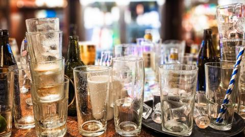 A collection of stacked, empty glasses standing on a bar