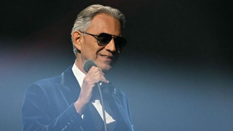 Andrea Bocelli wearing sunglasses and a balck tuxedo