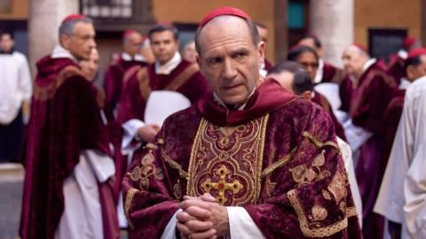 Ralph Feinnes in a scene from the movie, dressed in cardinal robes and looking worried.