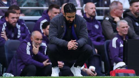 Ruben Amorim squats on the touchline with his head down