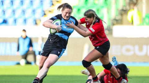 Briar McNamara holds off the tackle of a Brython Thunder player