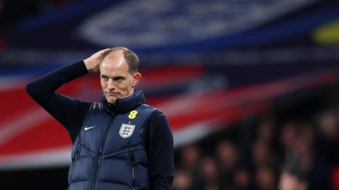 England manager Thomas Tuchel has one hand on his head and looks glum. 