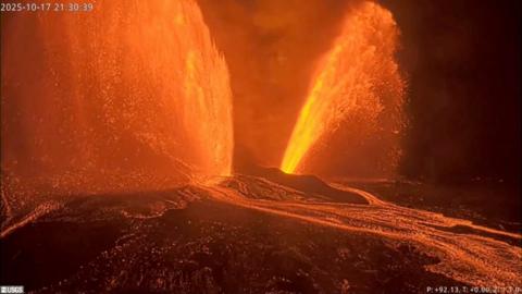 Molten lava erupts in two fountains from Kilauea volcano in Hawaii.