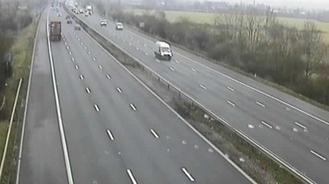 A screenshot from a grainy traffic camera on the M4. It shows completely cleared lanes and traffic running smoothly.