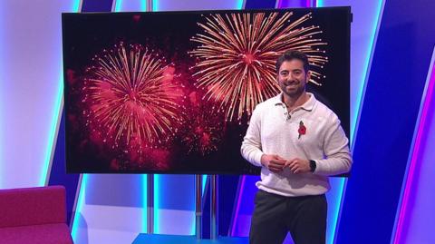 Ricky in the studio with fireworks in the screen