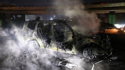 Smoke billows from the burnt remains of a Unifil vehicle