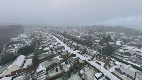 View above rows of residential roads covered in snow