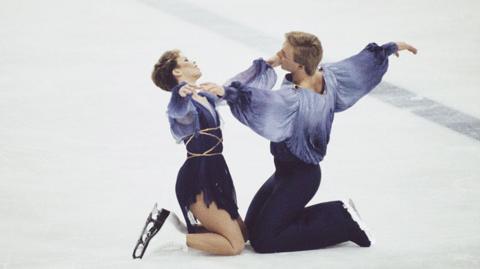 Ice-skating pair Jayne Torvill and Christopher Dean begin their routine with their knees on the ice.