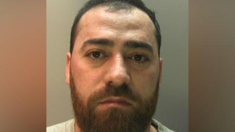 A man in a police mug shot. 
