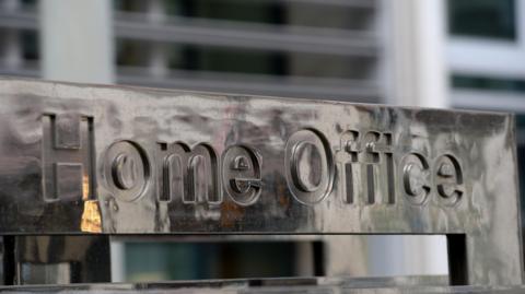 An image of a metallic sign reading 'Home Office'