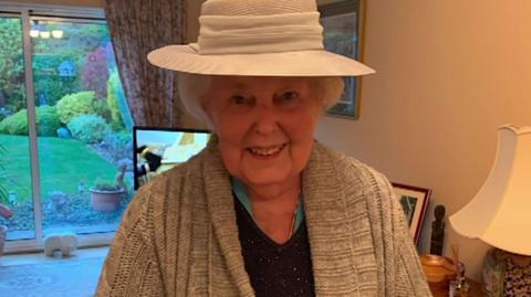 Mary Lamerton is smiling while wearing a lovely cream hat. 