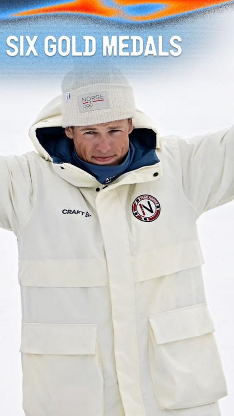 Johannes Klaebo smiles in white winter coat at the 2026 Winter Olympics