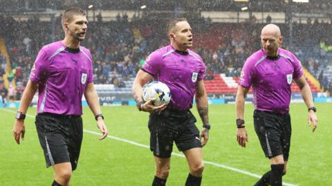 Referee Steve Martin and assistant referees Mark Dwyer and Johnathon Bickerdike walk off the pitch