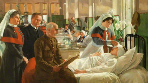 A bedside scene: this 1916 oil painting depicts the care provided to injured soldiers in a hospital ward during the First World War. As well as the patient there are four people attending to him.