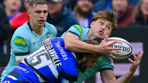 Leicester player is tackled by a Bath player