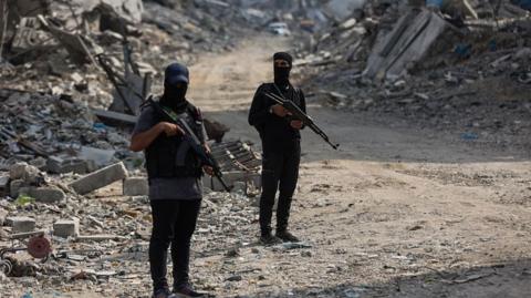 Hamas fighters guard an area of Gaza City where they are searching for the bodies of hostages with the help of the International Committee of the Red Cross (ICRC), in northern Gaza (3 November 2025)