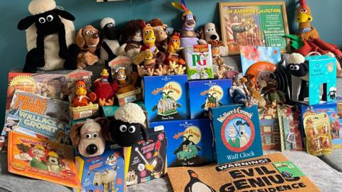 Part of Mel Harrison's Wallace and Gromit collection piled up on her sofa. It includes a door mat, teddies, books and tea bags.