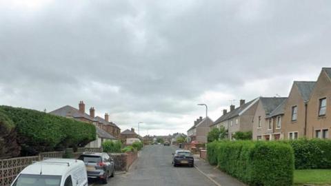 A suburban street in Annan with houses up both sides and cars parked