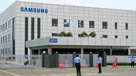 Security personnel stand guard at Samsung India's plant in Sriperumbudur, near Chennai on September 11, 2024, as workers stage a protest to demand higher wages and recognition of their union. Samsung Electronics workers in southern India went on strike from September 9 to demand better pay and working hours, with the consumer tech giant promising the industrial action would not impact consumers. (Photo by R.Satish BABU / AFP) (Photo by R.SATISH BABU/AFP via Getty Images)