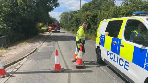 A police car and orange cones