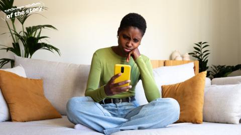 Young person looking at their phone in dismay
