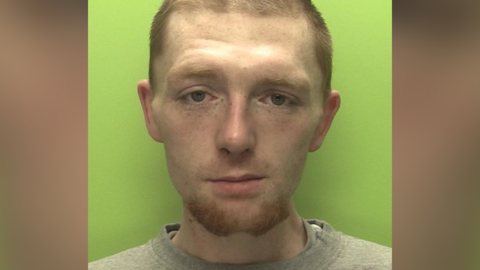 Custody photo of Callum Northage wearing grey t-shirt with green background