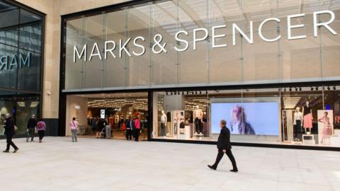 People walking in front of a Marks & Spencer store