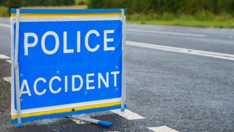 Blue police sign with POLICE ACCIDENT in white writing on a road