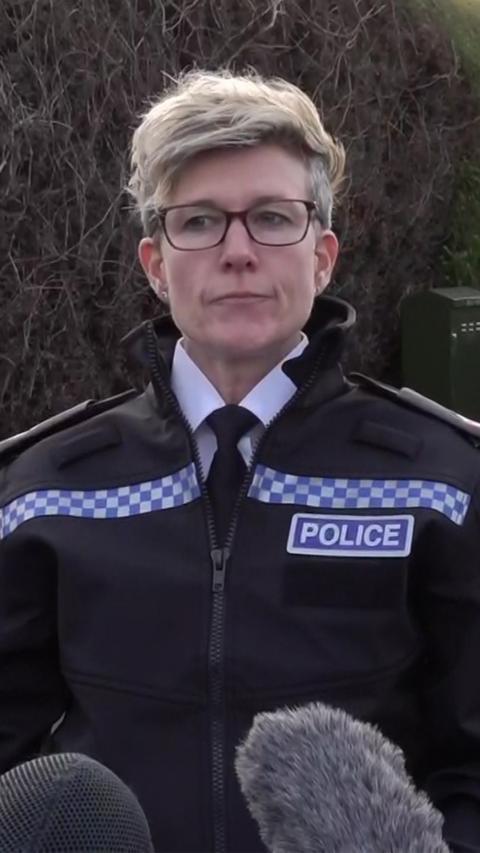 Supt Jen Appleford stood in black uniform with police and white letters saying police