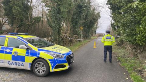 A police officer stands at a cordon at the scene of the crash at Menlo Pier near Galway city