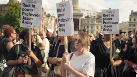 Women holding signs that read 'Rest in power Professor Jason Arday'