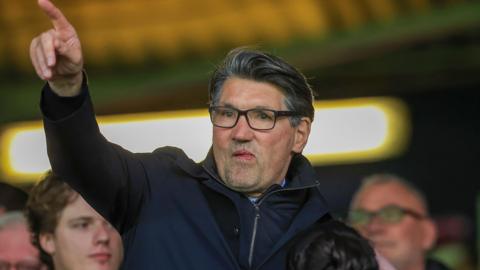 Mick Harford pointing while in the stands at Kenilworth Road 