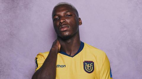 Moises Caicedo posing with his hand behind his neck for a Fifa photoshoot with Ecuador